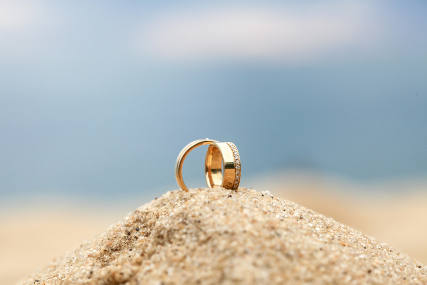 anillos de matrimonio de oro para hombre y mujer encima de la arena