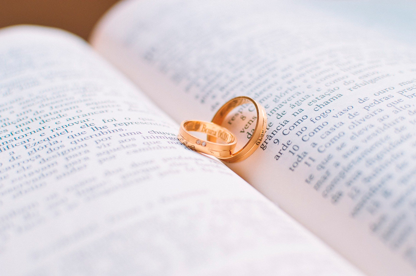 anillos de oro encima de un libro abierto